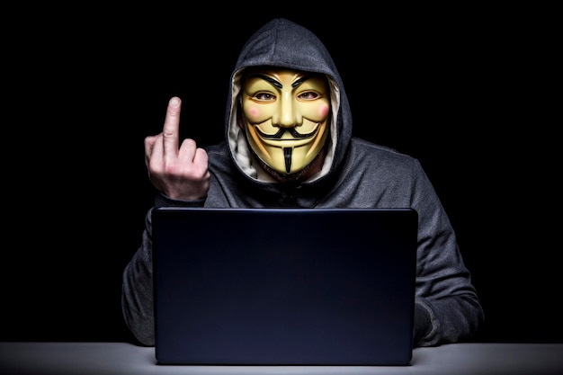 Hombre con máscara usando una computadora portátil contra un fondo negro