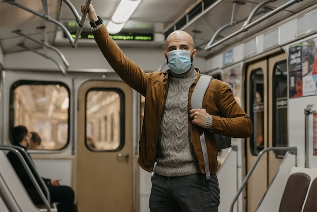 Un hombre con una mascarilla médica en la estación de metro.