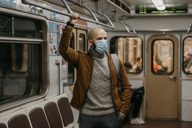 Un hombre con una mascarilla médica en la estación de metro.