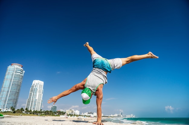 Hombre masculino de pie en su mano con Miami Beach en segundo plano.