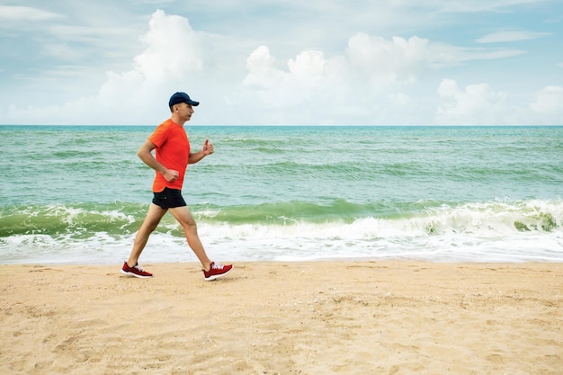 Hombre mayor activo corriendo por la playa de arena Estilo de vida saludable Jogging