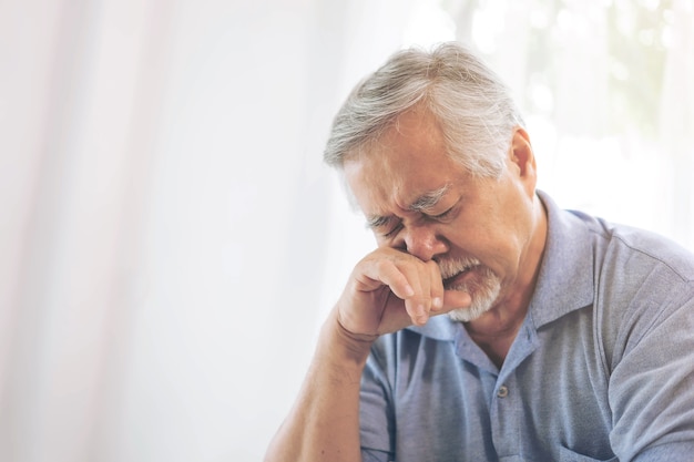 Hombre mayor asiático, anciano jubilado que se despierta con alergias, congestión nasal debido al cambio climático, pacientes ancianos en la cama en casa - concepto médico y sanitario