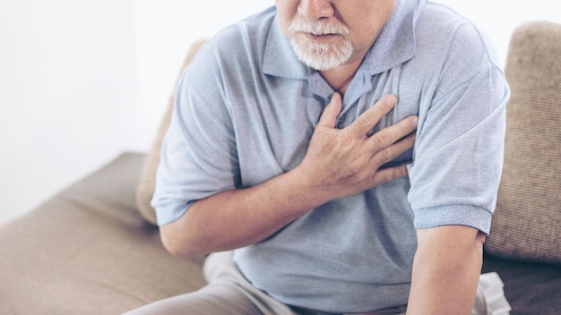 Hombre mayor asiático que sufre de dolor fuerte en su pecho ataque al corazón en casa enfermedad cardíaca mayor