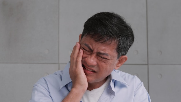 Foto hombre mayor asiático que sufre de dolor de muelas
