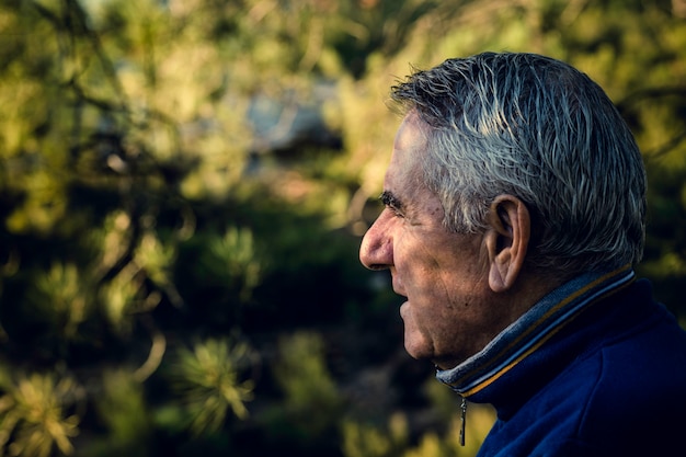 Foto hombre mayor atractivo con el pelo gris que mira en primero plano