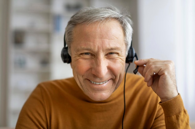 Hombre mayor con auriculares tiene llamada de video