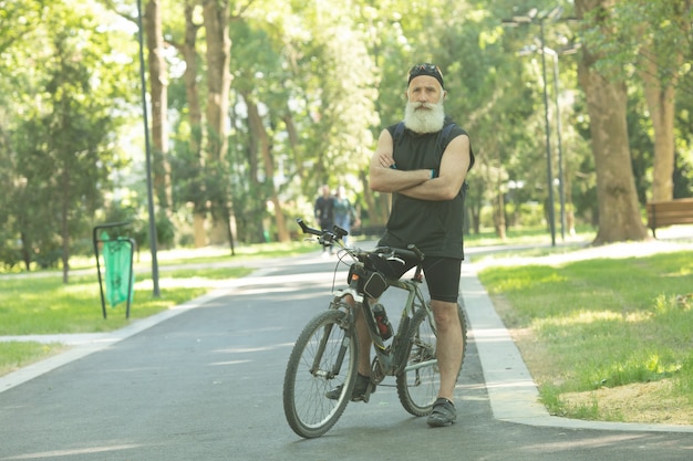 Hombre mayor barbudo con una bicicleta