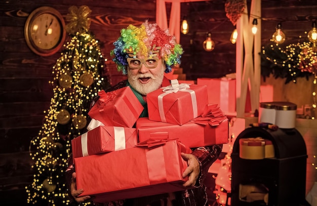 El hombre mayor barbudo celebra el entretenimiento de la fiesta de Navidad Vacaciones de invierno Decoraciones navideñas en casa Hombre maduro con barba blanca Hocus pocus Espíritu navideño Payaso alegre peinado colorido