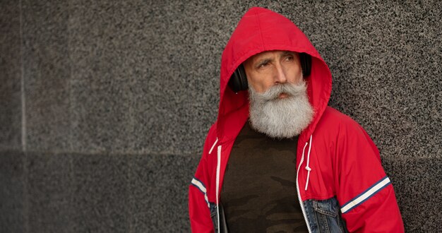 Un hombre mayor barbudo de moda escuchando música al aire libre. hombre maduro de moda.