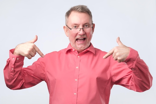 El hombre mayor con camisa roja y gafas está orgulloso