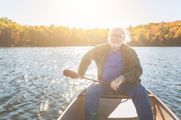 Hombre mayor con canoa remando en un día soleado