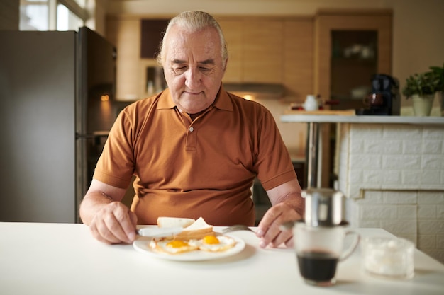 hombre mayor, comida, huevos fritos