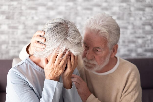 Foto un hombre mayor consolando a su deprimida y triste esposa infeliz anciana sentada en un sofá en casa