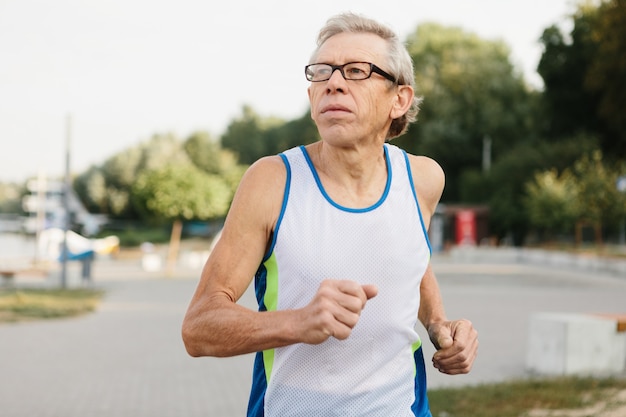 El hombre mayor se dedica a correr al aire libre. Foto de alta calidad