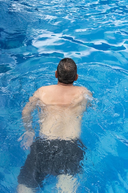 Hombre mayor divirtiéndose en la piscina