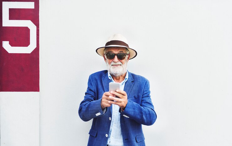 El hombre mayor está utilizando el teléfono móvil
