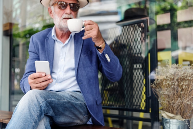 El hombre mayor está utilizando el teléfono móvil