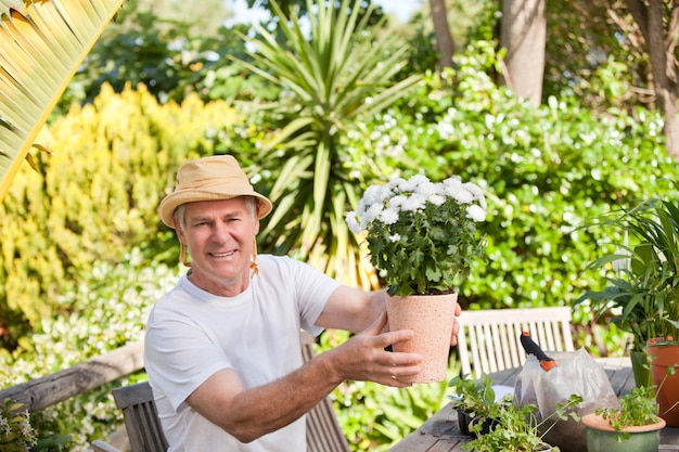 Hombre mayor con flores en su jardín