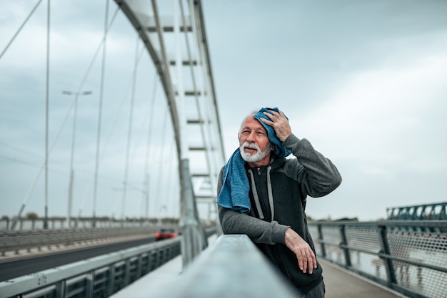 Hombre mayor hermoso que usa una toalla después de actividad