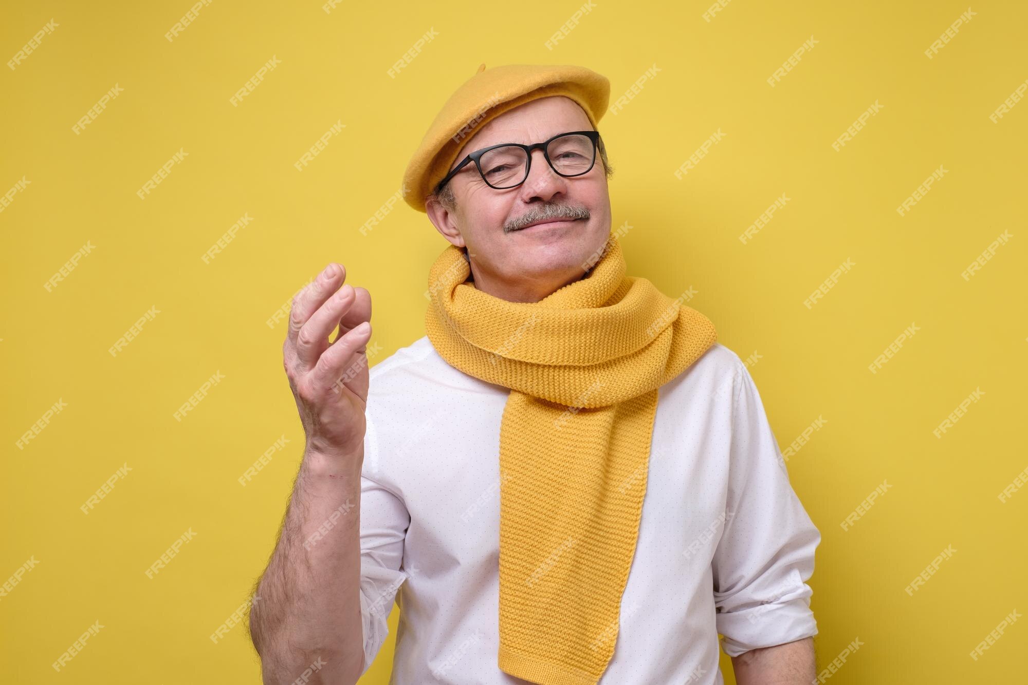 Hombre mayor hispano boina amarilla y mirando con una sonrisa a la cámara | Foto Premium