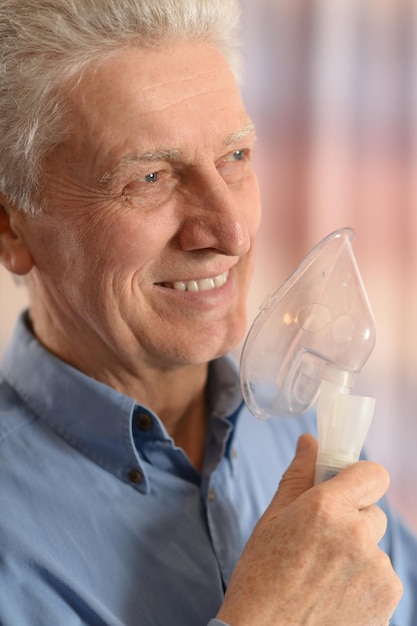 Foto hombre mayor con inhalador