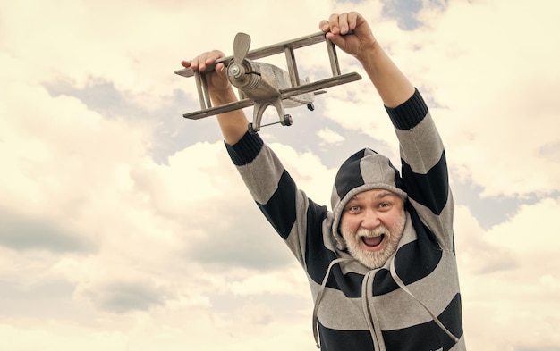 hombre mayor libre en el fondo del cielo hombre mayor en la jubilación hombre mayor jubilado con avión de juguete al aire libre