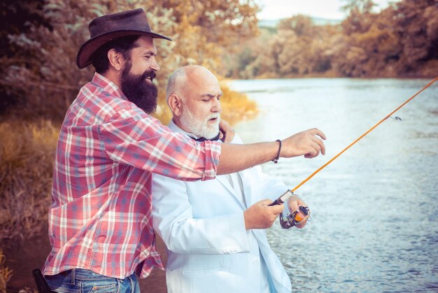 Hombre mayor maduro con un amigo pescando vacaciones de verano feliz gente alegre hombres barbudos atrapando fis