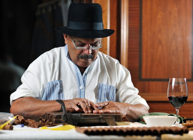 Hombre mayor mayor haciendo cigarros cubanos hechos a mano de lujo