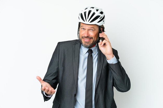 Hombre mayor de negocios con casco de bicicleta aislado de fondo blanco manteniendo una conversación con alguien por teléfono móvil
