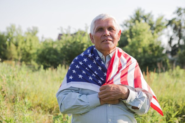 Hombre mayor patriótico con la bandera americana