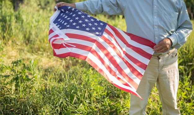 Hombre mayor patriótico con la bandera americana