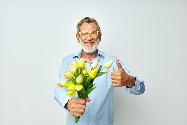 Hombre mayor de pelo gris un ramo de flores con gafas como fondo claro de regalo