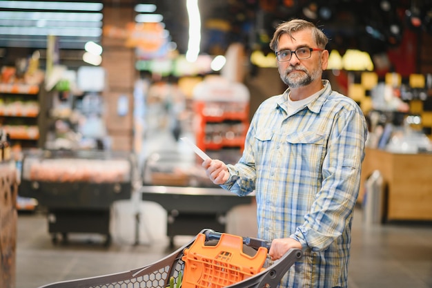 Hombre mayor en productos de la tienda de comestibles