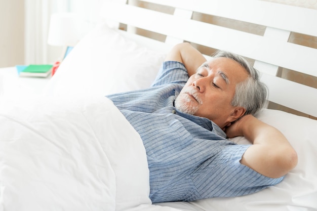 Hombre mayor que sufre en la cama no puede dormir de insomnio, hombre mayor, anciano durmiendo en la cama por la mañana - concepto de problema de insomnio senior