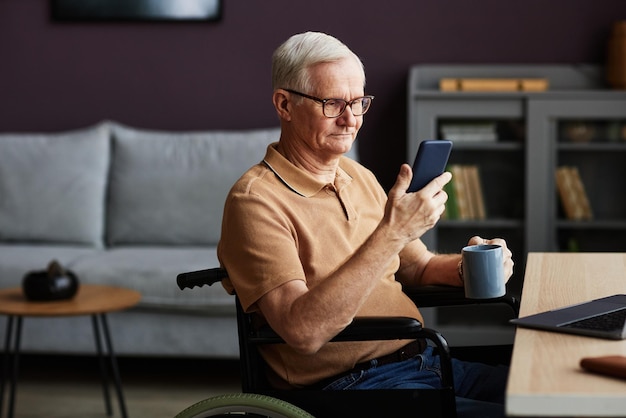 Hombre mayor que usa un teléfono inteligente para leer