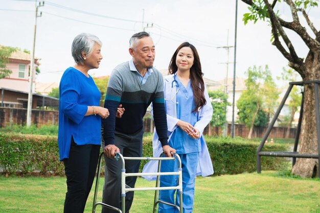 Foto hombre mayor en silla de ruedas con médico y esposa