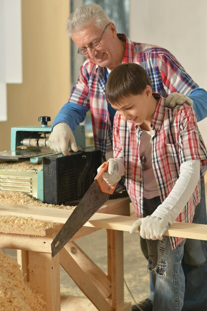 Foto hombre mayor y su nieto reparando en la habitación