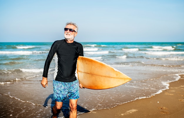 Un hombre mayor con una tabla de surf