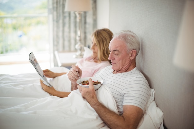 Hombre mayor, teniendo desayuno, en cama