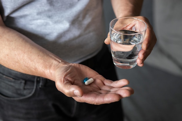 Foto hombre mayor toma pastillas de drogas a mano