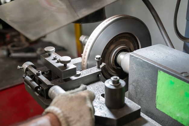 Hombre mecánico reparando frenos de disco coche