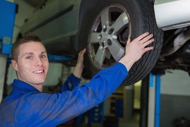 Foto hombre mecánico trabajando en la rueda del coche