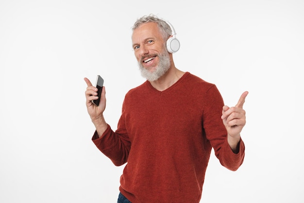 Foto hombre de mediana edad adulto activo escuchando la lista de reproducción de canciones de música ebook podcast en auriculares en teléfono móvil en línea aislado en fondo blanco