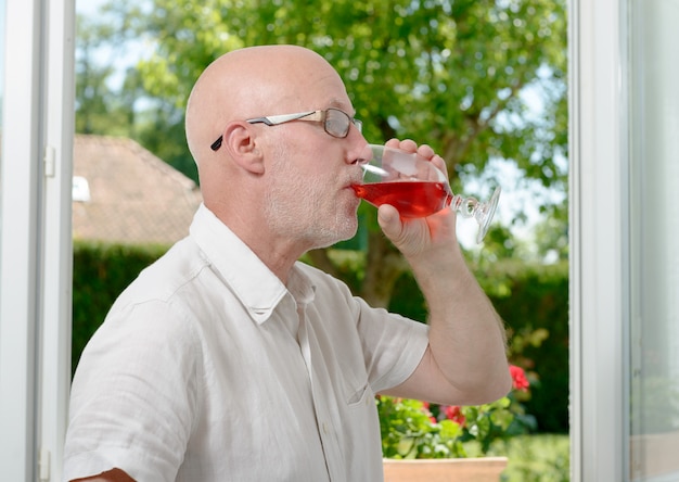 Hombre de mediana edad bebiendo una copa de vino