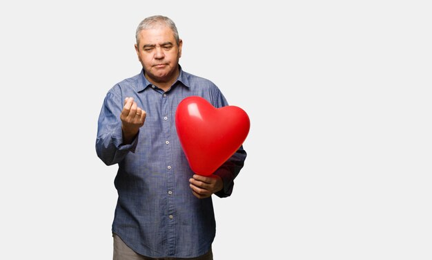 Hombre de mediana edad celebrando el día de San Valentín haciendo un gesto de necesidad