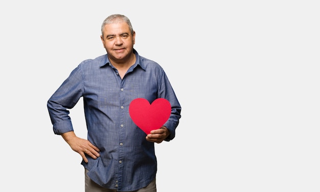 Hombre de mediana edad celebrando el día de San Valentín con las manos en las caderas