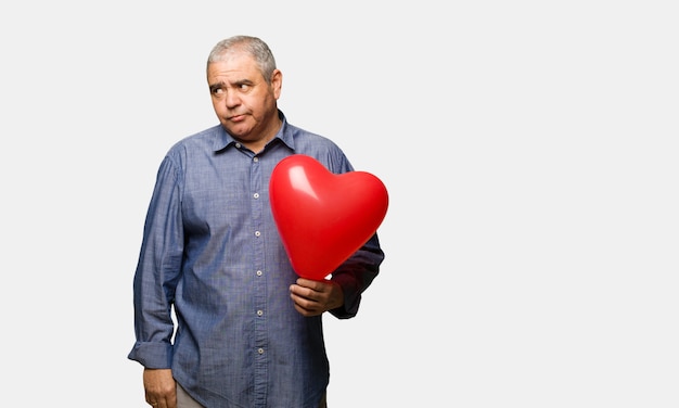 Hombre de mediana edad celebrando el día de San Valentín pensando en una idea