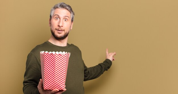 Hombre de mediana edad con un cubo de palomitas de maíz