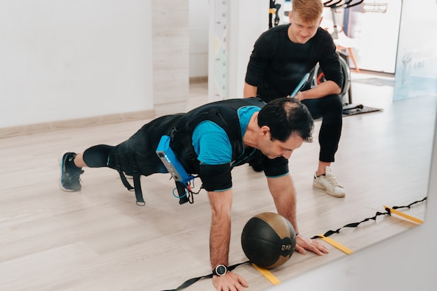 Hombre de mediana edad haciendo ejercicio con el balón medicinal