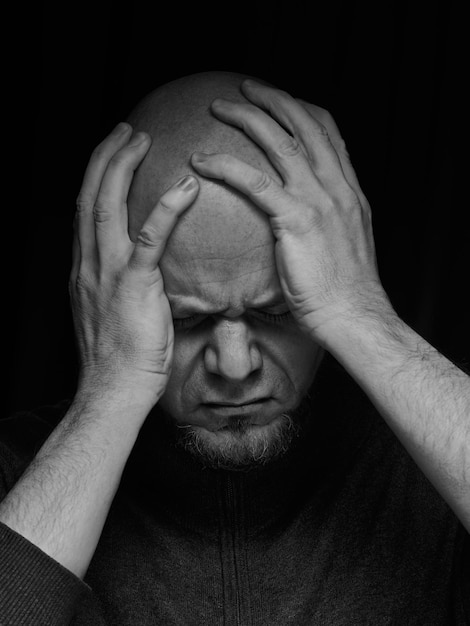 Foto hombre de mediana edad con las manos sobre la cabeza